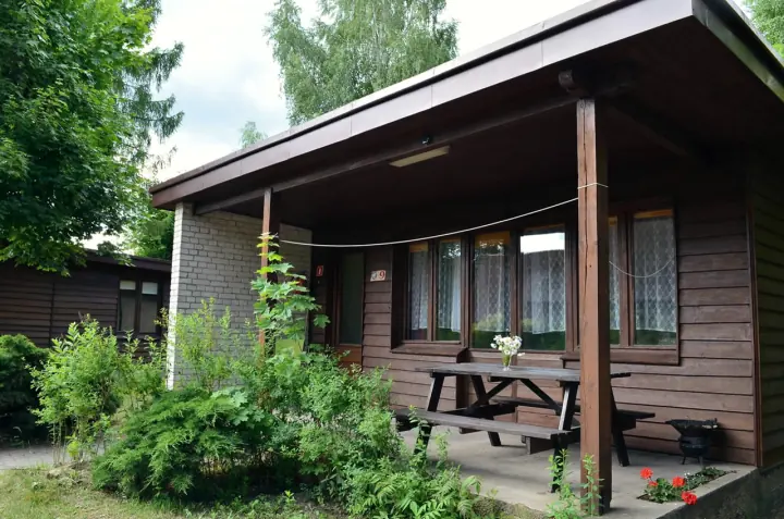 Taras domku parterowego ze stołem piknikowym i pelargoniami