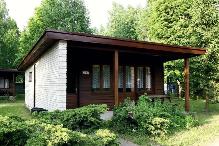 Domek parterowy z białej cegły i drewna z zadaszonym tarasem