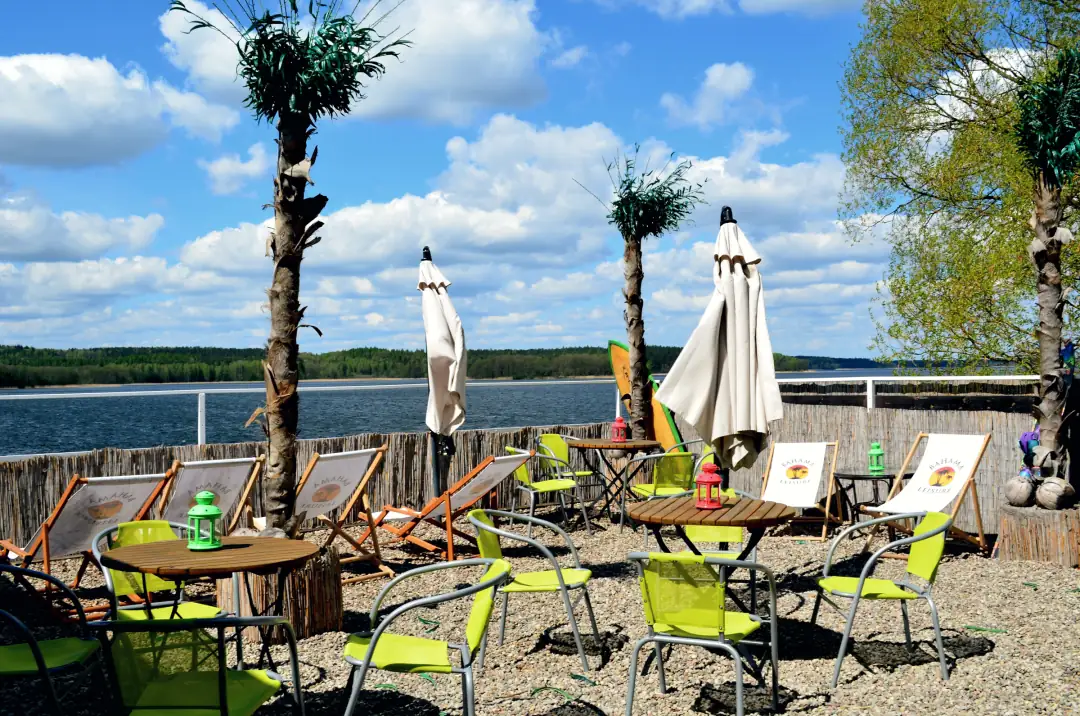 Beach Bar w&nbsp;pełnym słońcu: palmy, leżaki i&nbsp;stoliki nad Jeziorem Charzykowskim