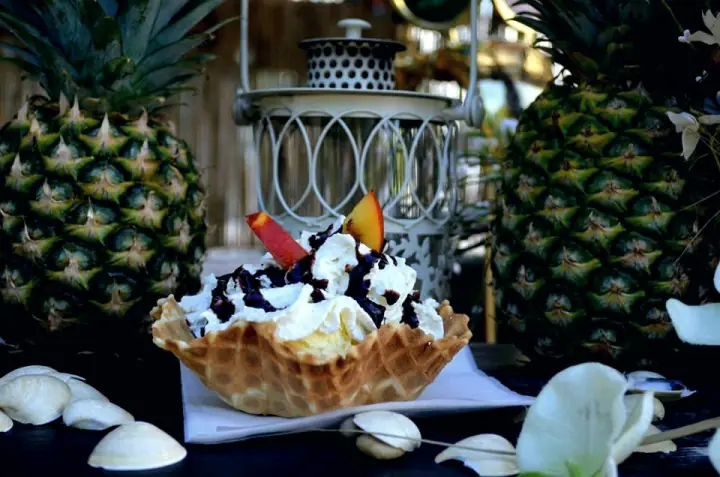 Lody w&nbsp;wafelkowej miseczce z&nbsp;bitą śmietaną i&nbsp;owocami